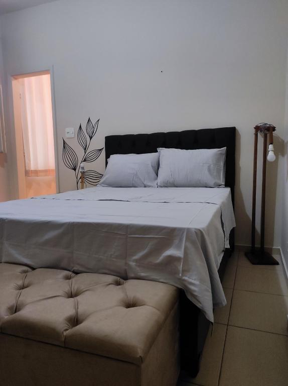 uma cama e um sofá num quarto em Lindo apto vista lateral do mar Itararé São Vicente em São Vicente