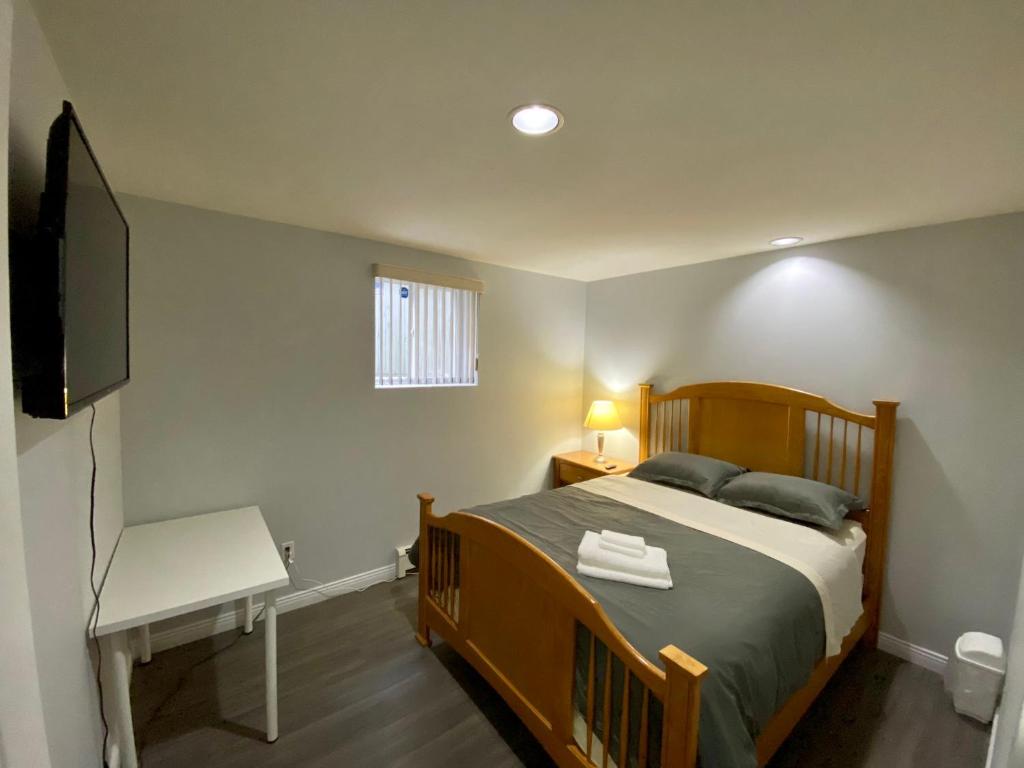 a bedroom with a bed and a flat screen tv at Anne's BNB in Surrey