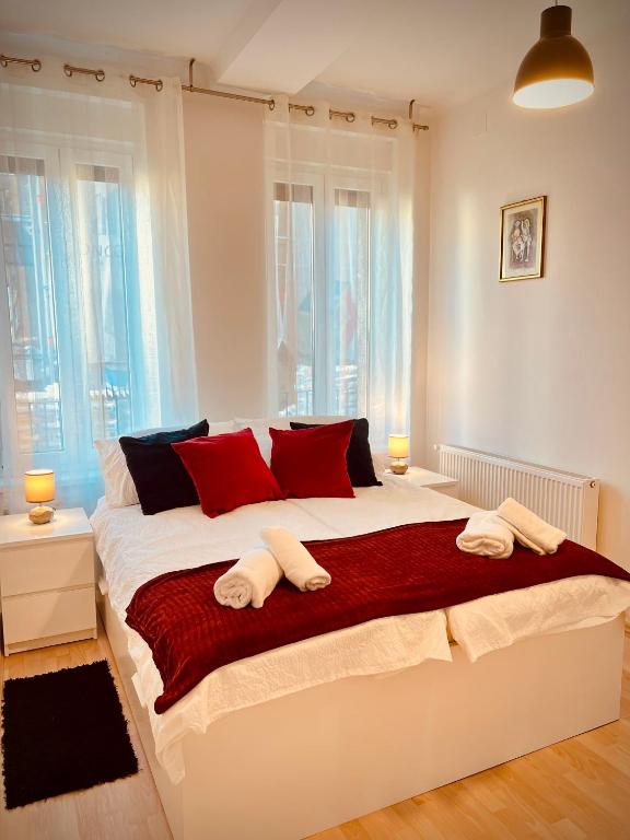 um quarto com uma grande cama branca com almofadas vermelhas em The Downtown Pearl em Zagreb