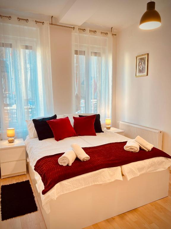 sypialnia z dużym białym łóżkiem z czerwonymi poduszkami w obiekcie The Downtown Pearl w Zagrzebiu