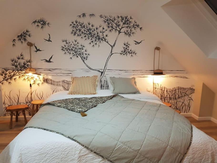 a bedroom with a bed with birds on the wall at Le Bon Temps, pour une douce parenthèse in Saint-Martin-lez-Tatinghem