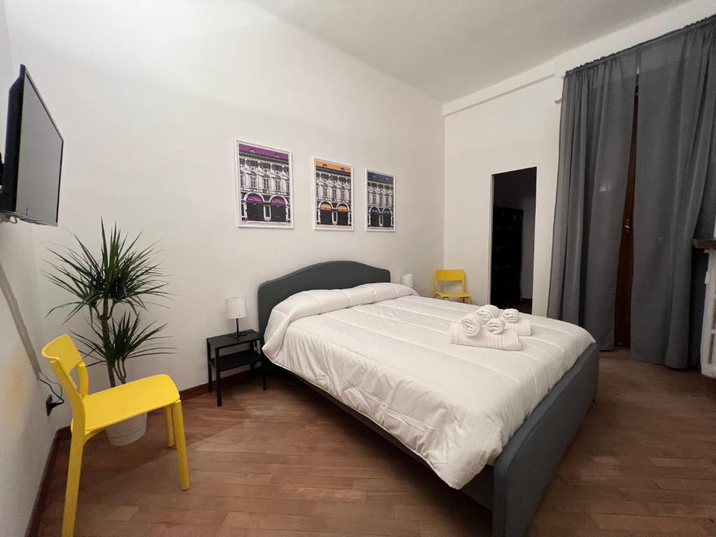 a bedroom with a bed and a yellow chair at Appartamento Cenisia Fermata Racconigi in Turin