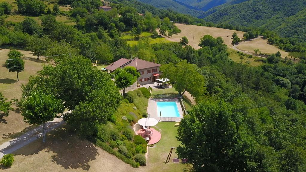 an aerial view of a house with a swimming pool and trees at La Scatolaia in Stia