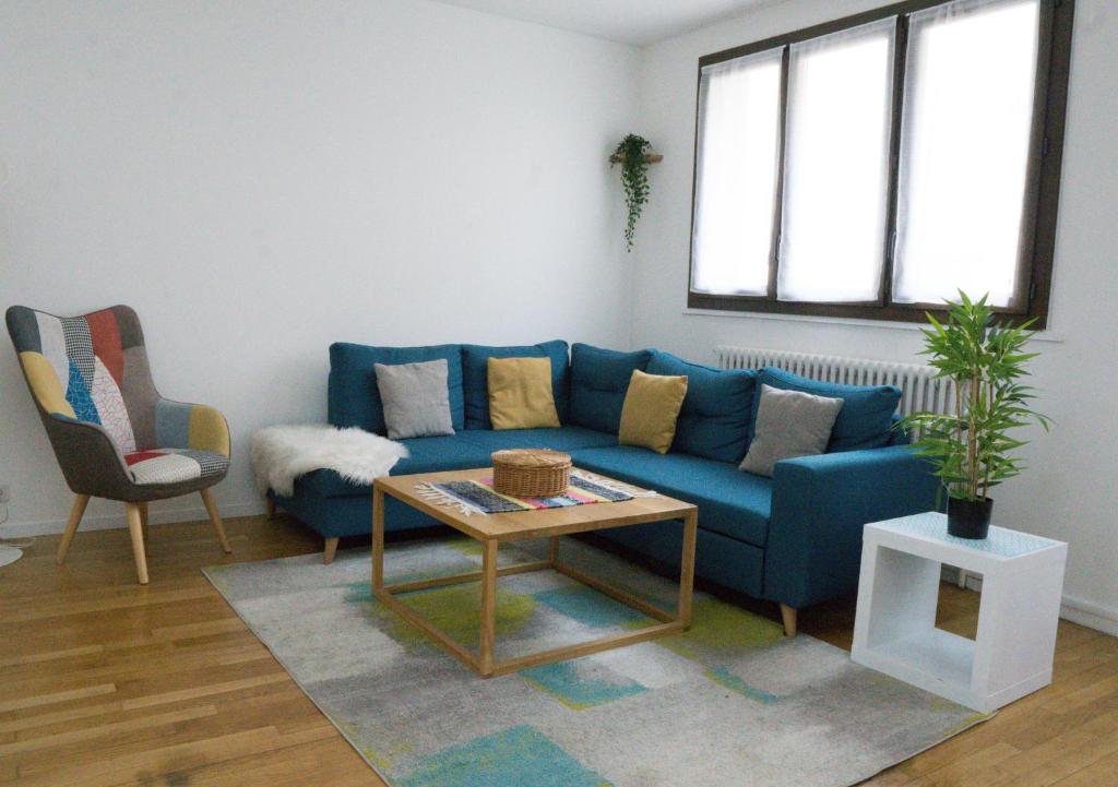 sala de estar con sofá azul y mesa en EXIGEHOME-Grande maison aux portes de Paris, en Antony