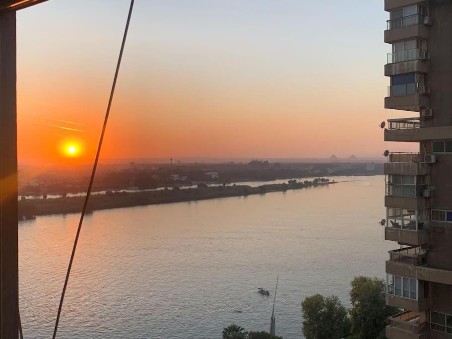 a view of a river at sunset from a building at Schöne Wohnung mit Blick auf Nil und Pyramiden in Cairo