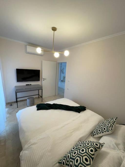 um quarto branco com uma cama e uma televisão em Apartament Timisoara 6 em Timisoara