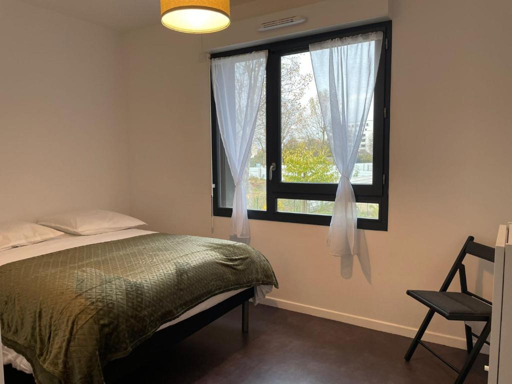 - une chambre avec un lit et une fenêtre avec une chaise dans l'établissement Charmante maison de ville 4 chambres proche de Paris, à Chevilly-Larue