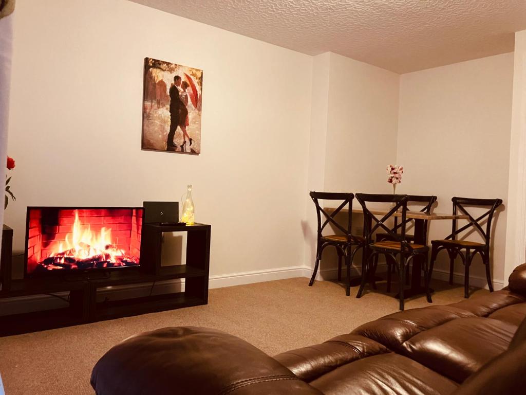 sala de estar con sofá y chimenea en Cosy home near hospital, en Carlisle