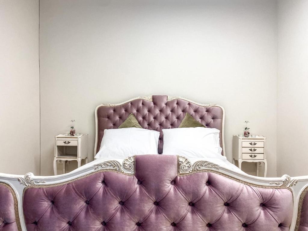 sypialnia z fioletowym łóżkiem i 2 szafkami nocnymi w obiekcie Krioklio Namelis Verkiuose w Wilnie