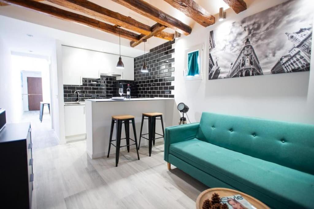 sala de estar con sofá verde y cocina en Fantastic flat in Call-Preciados-Gran Vía 4P, en Madrid