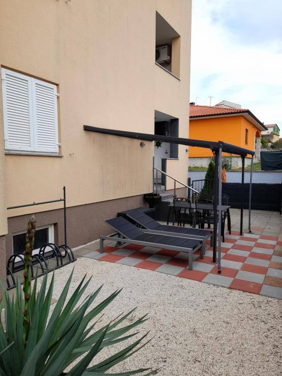 a patio with chairs and tables on a building at Apartment Adi in Rovinj