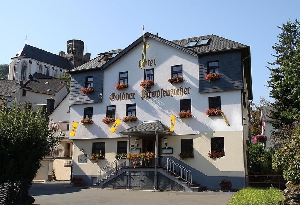 um grande edifício branco com flores na frente em Goldener Pfropfenzieher em Oberwesel