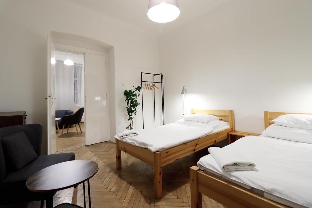 Habitación con 2 camas, silla y mesa. en Teytz Apartments, en Praga