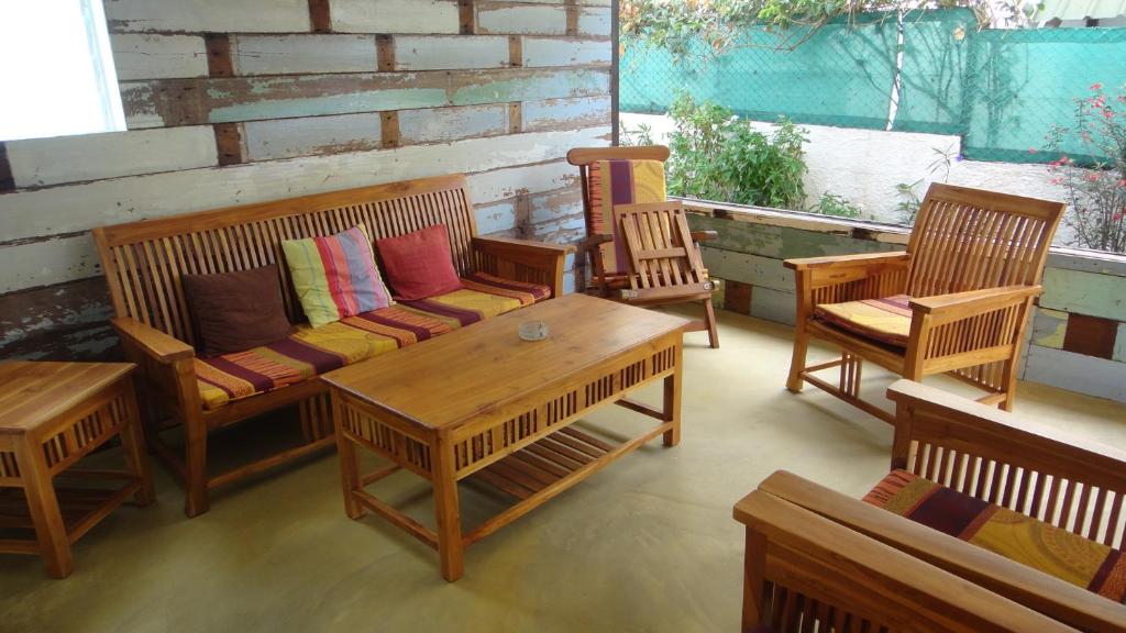 un portico con sedie, divano e tavolo di Colibri Beach Villas a Trou d'Eau Douce
