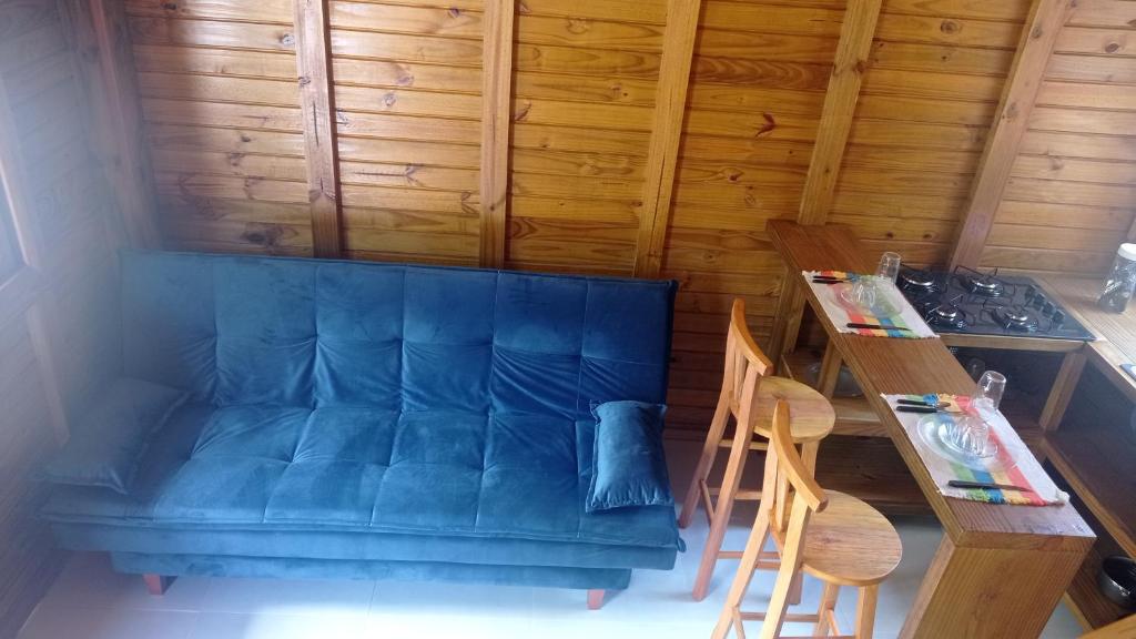 sala de estar con sofá azul y mesa en Residencial Aracuã Praia Brava, en Itajaí