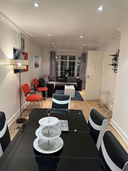 uma sala de estar com uma mesa preta e cadeiras em Beautiful 3 Bedrooms town house with parking em Redbridge