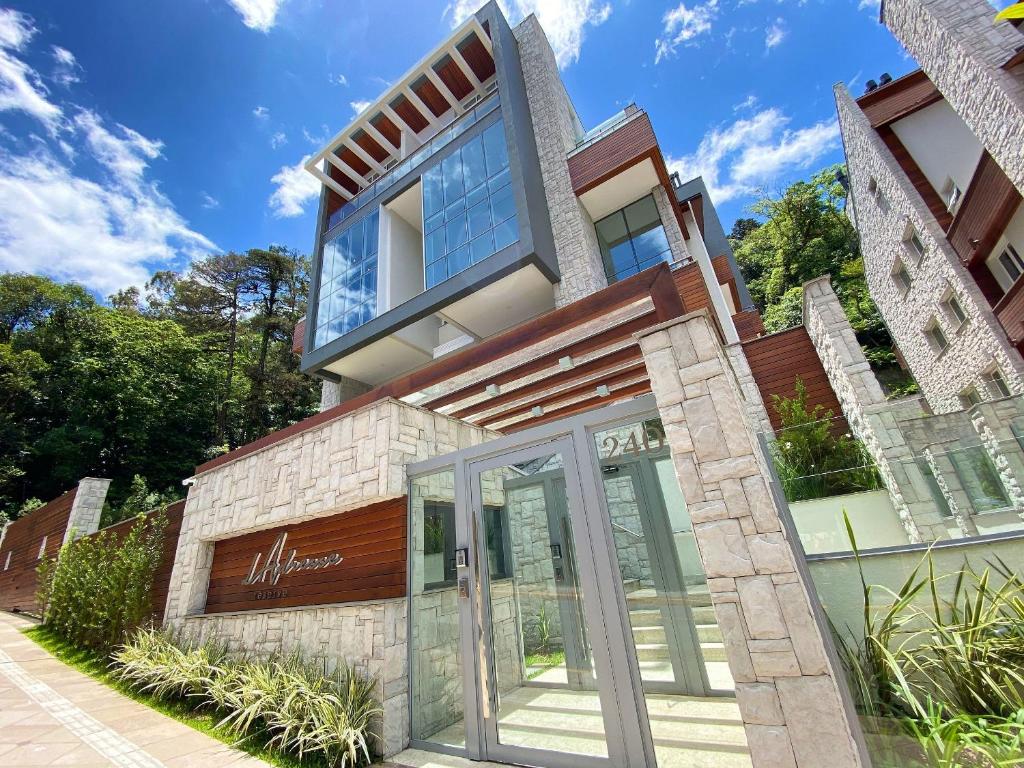 uma casa com uma porta de vidro em frente em Apartamentos L'adress Reserve CENTRO by Achei Gramado em Gramado