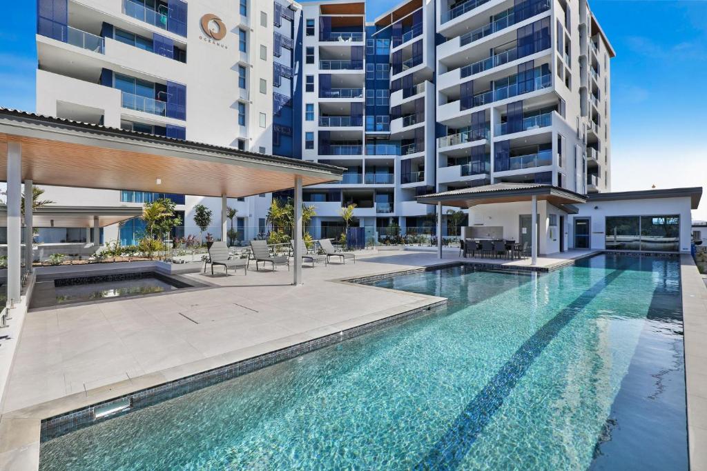 an empty swimming pool in front of a building at Oceanus Bokarina Beach in Kawana Waters
