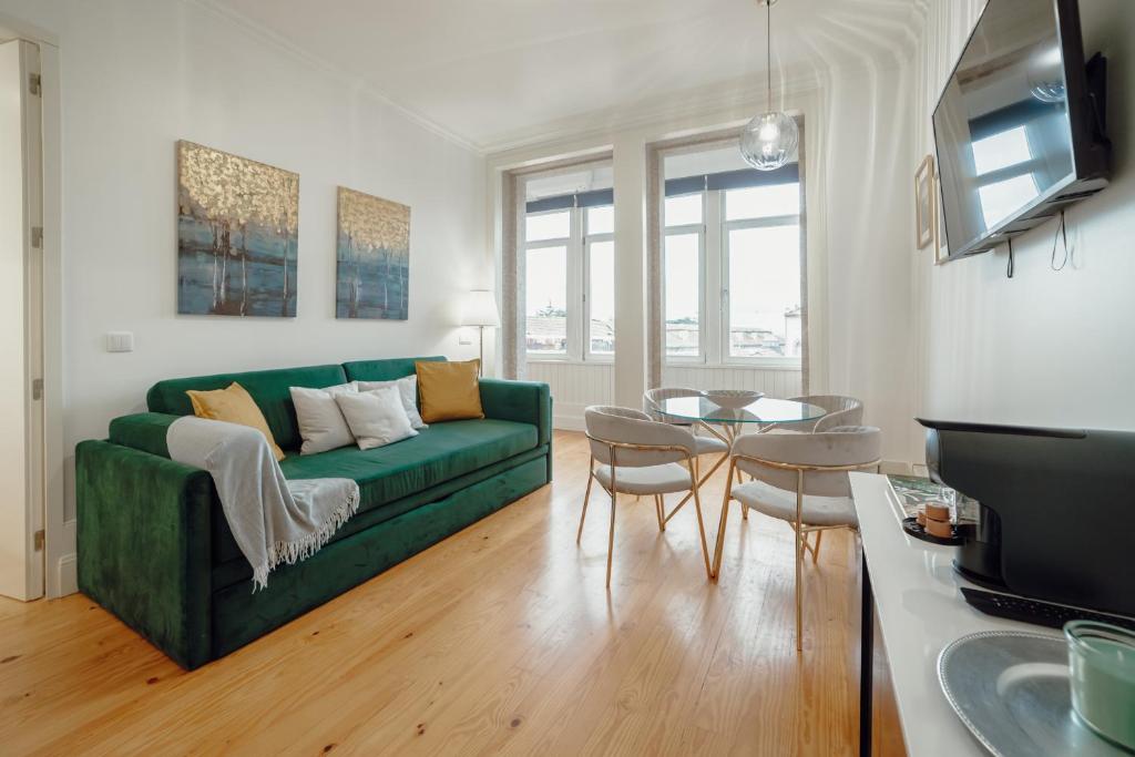 - un salon avec un canapé vert et une table dans l'établissement Downtown Premium Apartment by Vacationy, à Porto
