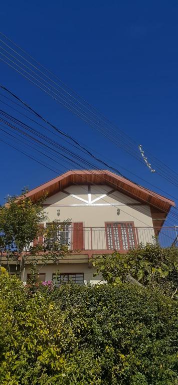 a white building with red doors on top of it at Casa Bela Vista in Campos do Jordão