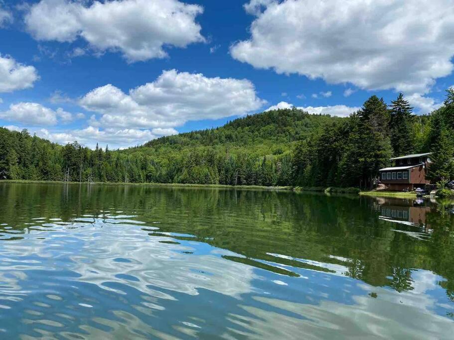 Blick auf einen See mit einem Haus am Ufer in der Unterkunft Middle Pond Cabin- Direct ATV & Snowmobile Access in Pittsburg