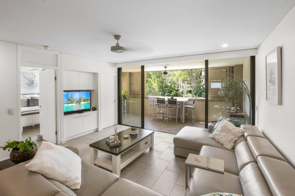 a living room with a couch and a table at 303 Sea Temple Renovated Apartment in Palm Cove