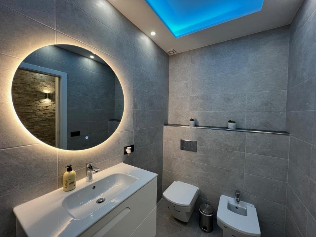 y baño con lavabo, espejo y aseo. en Luxury Apartment Orlando, en Adeje