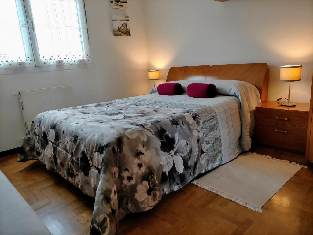 een slaapkamer met een bed met een zwart-witte deken bij Apartamento de 2 hab. con todo lo necesario. in Gijón