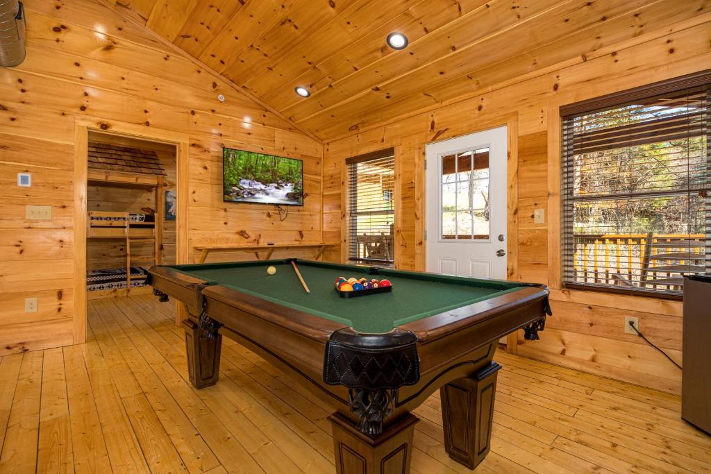 a pool table in a room with wooden walls at Mountain Haven with 2 HotTubs, Thtr &Game Rm, Summer Special,1mi to the Parkway! - Ideal for Family Reunions or Group Getaways! Home away from home in Pigeon Forge