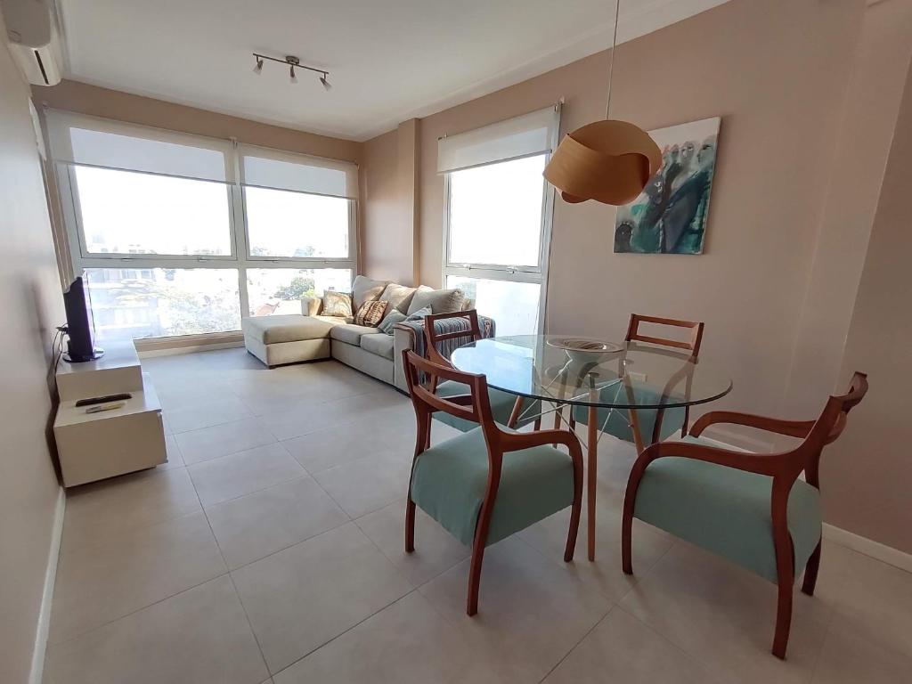 a living room with a glass table and chairs at Departamento Nuevo 2 amb con cochera Solo parejas o familias in Mar del Plata