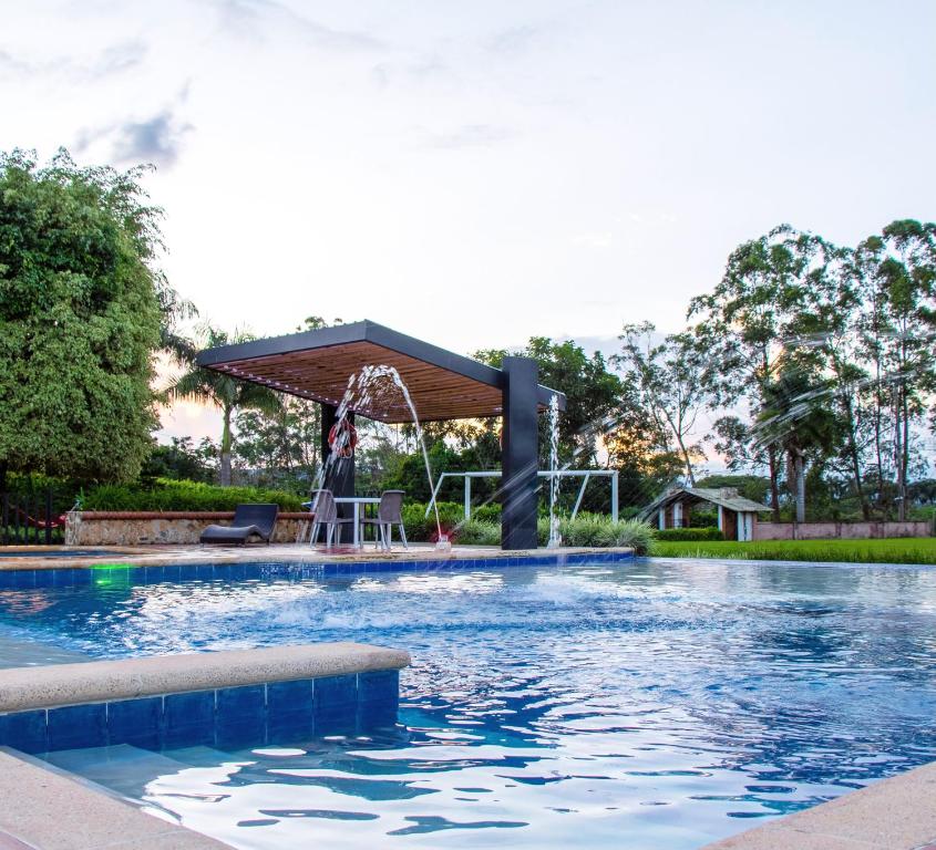 uma piscina com um gazebo num quintal em Finca Hotel Casa Nostra, villa Mariana em Quimbaya