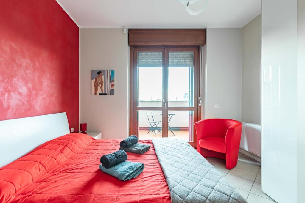 una camera con un letto rosso e una sedia rossa di La Casa Di Claudio - by Host4U a Melegnano