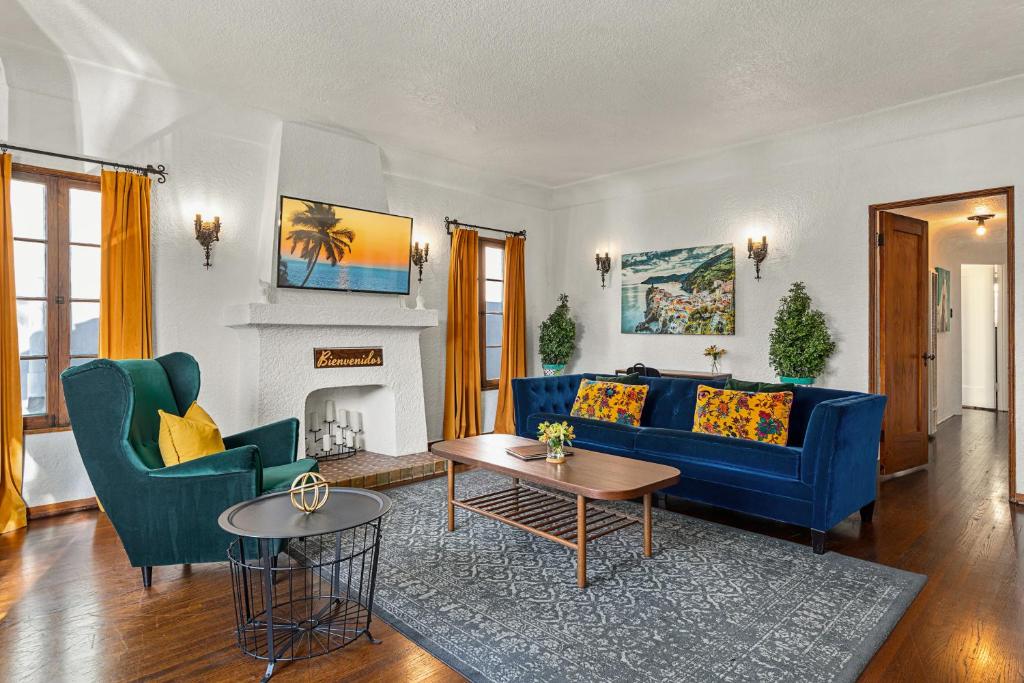 a living room with blue couches and a fireplace at Visit the Beach from a Historic Downtown Apartment - NRP21-00092 in Long Beach