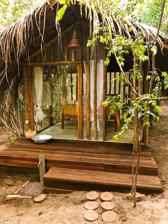 a small hut with a bench in the woods at Na Floresta Glamping in Pôrto de Pedras