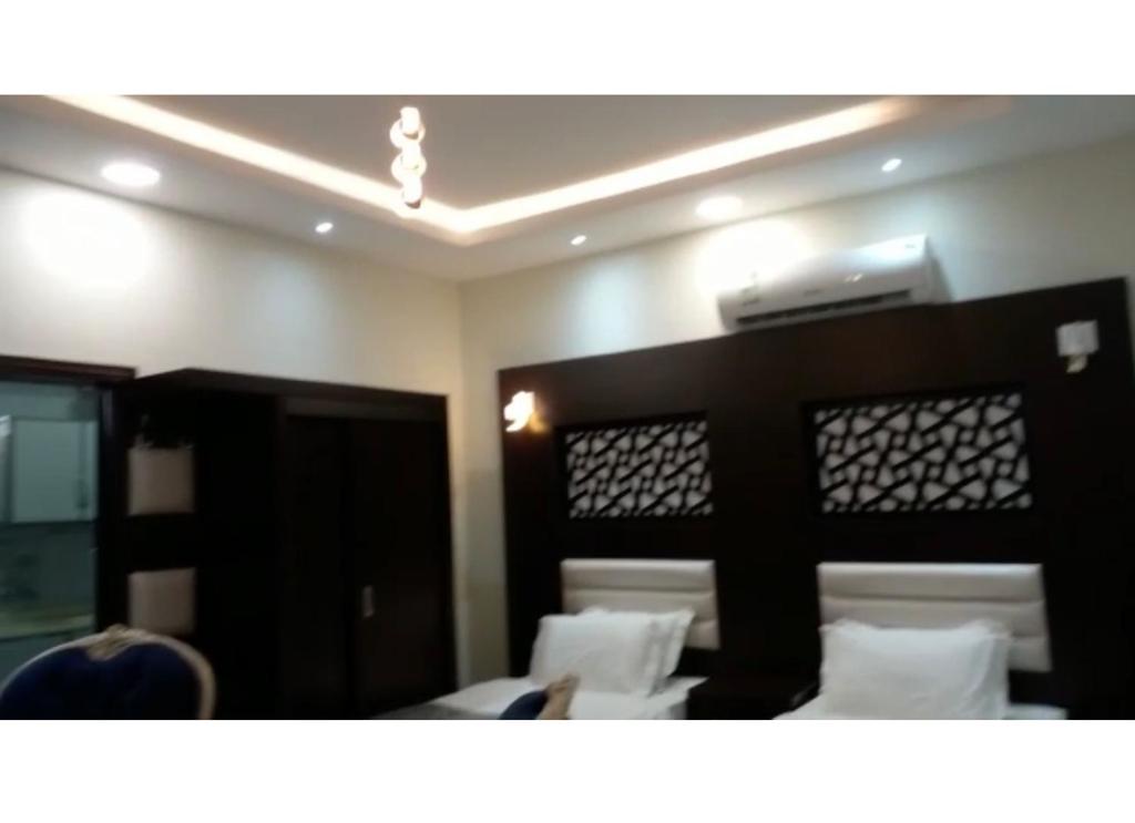 Camera dotata di letto con cuscini bianchi. di إعمار الشرفةللشقق المفروشه a Najran