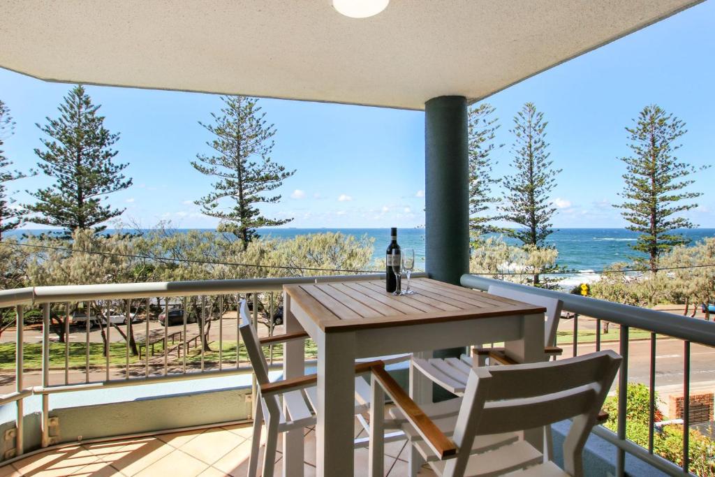 a table and chairs on a balcony with a view of the ocean at Seapoint Unit 14 32 Victoria Tce Kings Beach in Caloundra