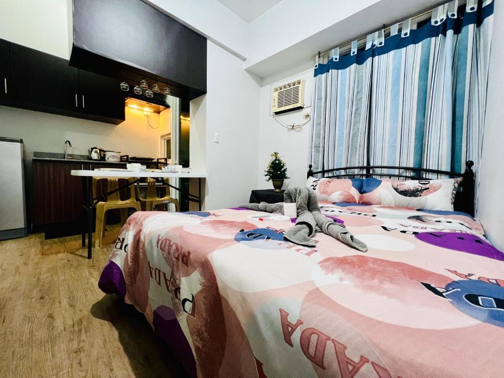 ein Schlafzimmer mit einem großen Bett und einer Hallo-Miezedecke in der Unterkunft At Home Condo With Free Pool Access in Manila