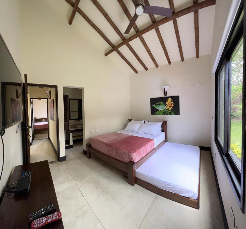 1 dormitorio con cama, escritorio y ventana en Fincas Panaca Villa Portal 9, en Quimbaya