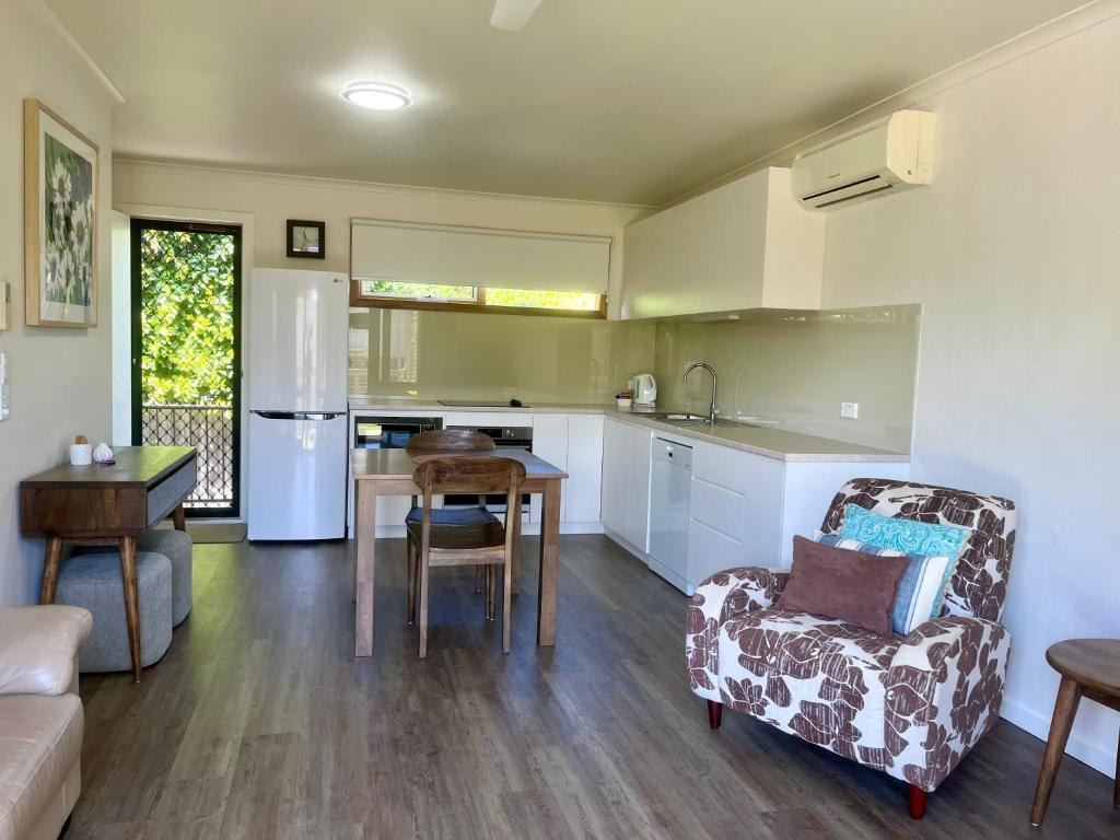 a kitchen and living room with a couch and a chair at Gowings of Mallacoota in Mallacoota