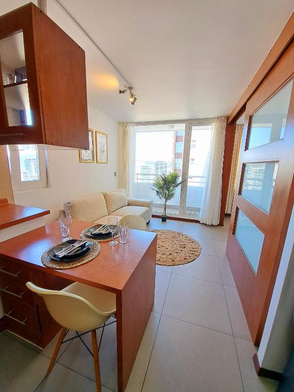 a kitchen and living room with a table and chairs at Céntrico y cómodo departamento in Concepción
