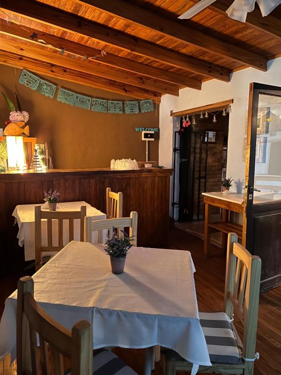 a dining room with a table and chairs and a kitchen at Hosteria Isabel in Las Grutas