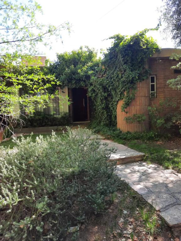 un patio con una casa de ladrillo con hiedra en Tu casa en el centro en San Rafael