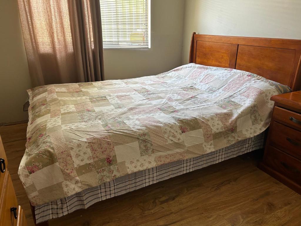 uma cama com uma colcha num quarto em Lovely house in canning vale em Perth