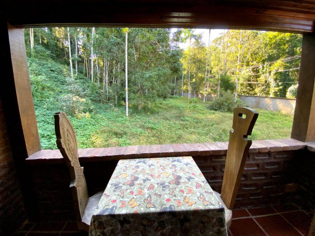 a table and two chairs in a window with a view at Pousada Donna Rose in Penedo
