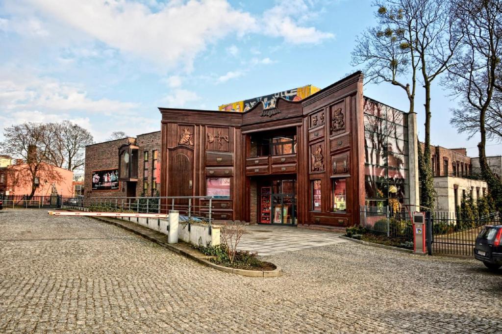 a large wooden building on the side of a street at Teatr Baj Pomorski in Toruń