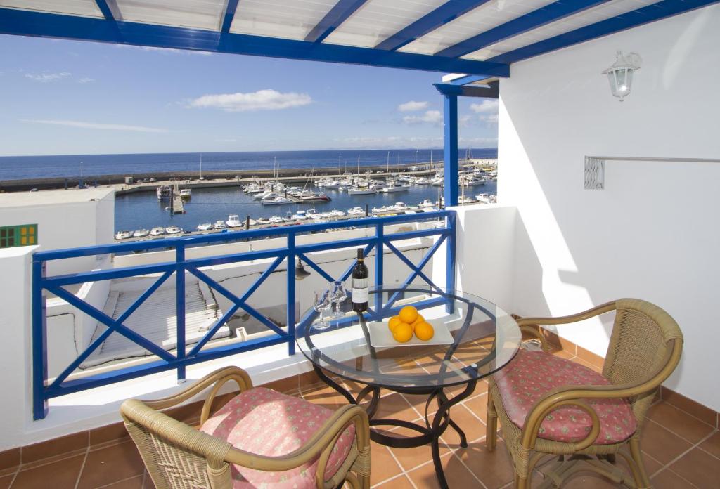 einen Balkon mit einem Glastisch und Stühlen in der Unterkunft Harbour Lights in Puerto del Carmen