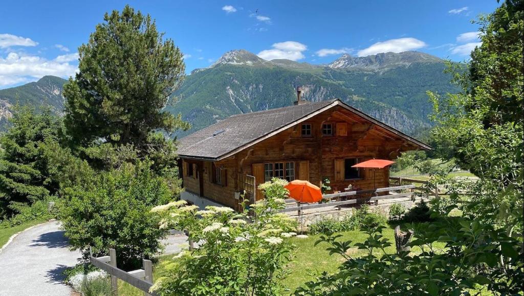 ein Holzhaus mit einem Berg im Hintergrund in der Unterkunft Chalet Albarose - Vercorin in Vercorin