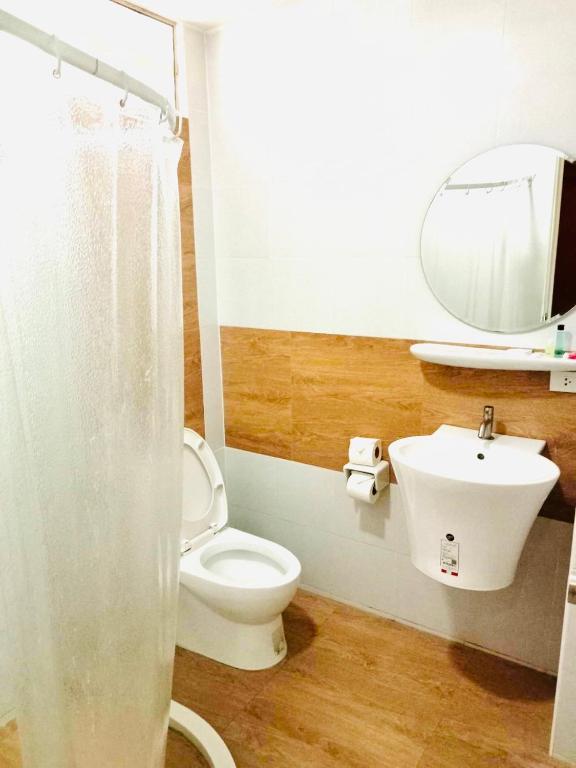 a bathroom with a toilet and a sink and a mirror at Garden Home Kata in Kata Beach