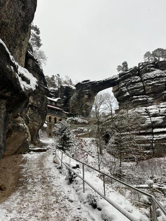 a snow covered path next to a stone bridge at Pension U Václava in Janov