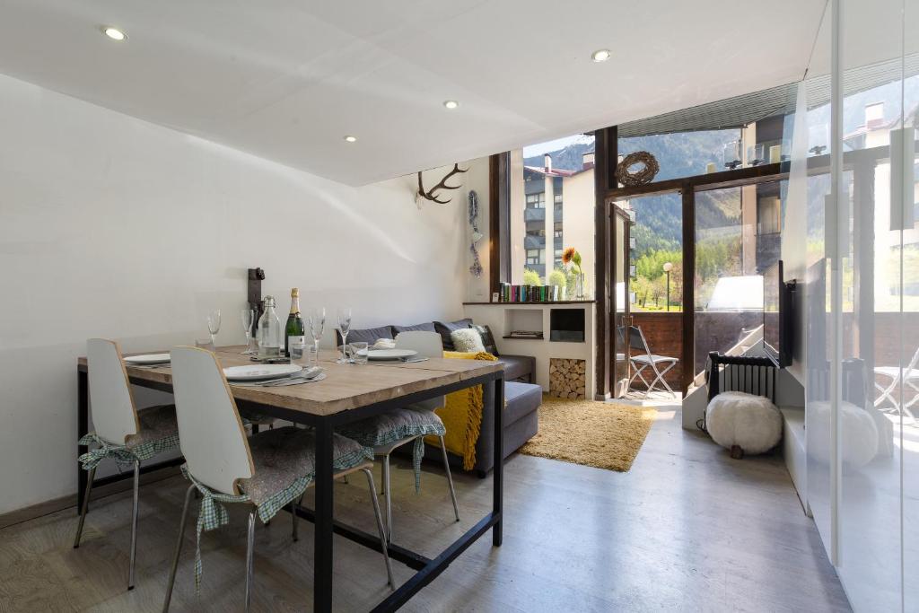uma sala de jantar e sala de estar com mesa e cadeiras em Résidence Grand Roc - Ancolies 028 - Happy Rentals em Chamonix-Mont-Blanc